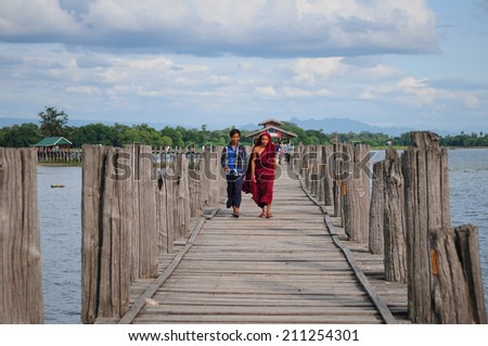 MANDALAY, MYANMAR - SEPTEMBER 2 : People are walking on U-Bein bridge on September 2, 2013, Mandalay, Myanmar. The U-Bein bridge is the longest teak bridge in the world