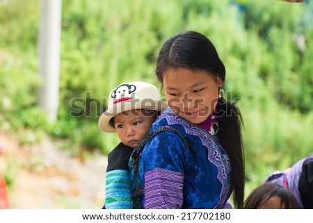 MOCCHAU, VIETNAM, SEPT 2: Unidentified H'mong ethnic minority woman with her son in a festival on September 2, 2014 in Mocchau, Vietnam. This is biggest festival of H'mong ethnic minority people.