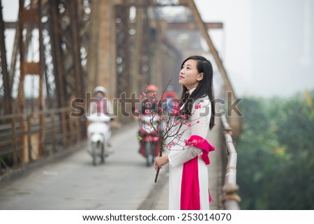 Vietnamese girl on Long Bien bridge in Hanoi, Vietnam.  Long Bien bridge is a historic cantilever bridge across the Red River in Hanoi city.