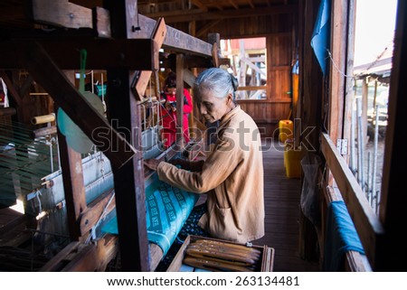 INLE LAKE, MYANMAR, FEB 27: An unidentified Burmese woman weaving clothe from lotus silk on February 27, 2015 in Inle Lake, Myanmar. Silk was produced from lotus is a speciality of Inle Lake area.
