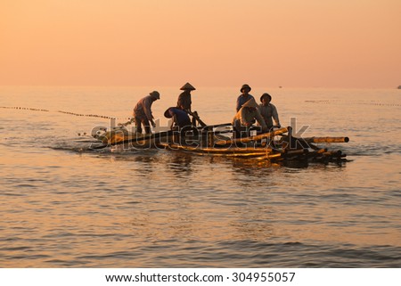 NAMDINH, VIETNAM, AUGUST 8, 2015,: Fishermen draw up a net to catch fishes on the beach in sunrise in Hai Ly, Nam Dinh. They go fishing at night and comeback in sunrise.