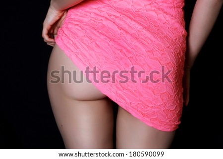 beautiful woman\'s ass body in fitting sexy pink dress. black background