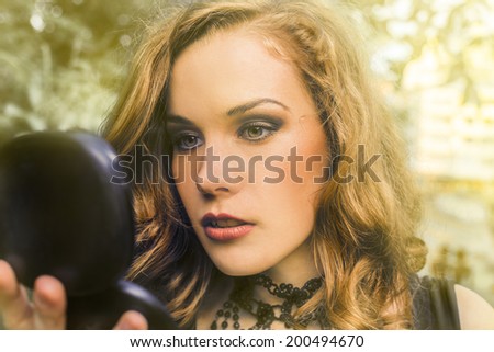 Beautiful woman outdoor portrait looking in mirror
