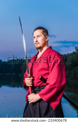 Man in ethnic samurai japanese clothing uniform with katana sword