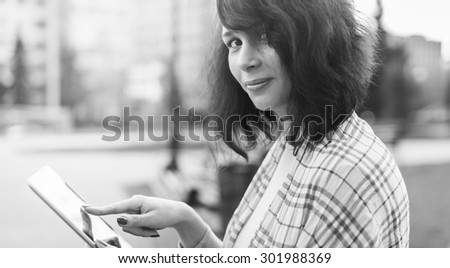 Black and white. Young woman with Tablet reading from ebook