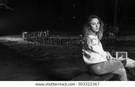 Black and white. Young woman sitting with Tablet and reading from ebook