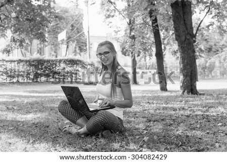 Black and White. BW. Young woman using tablet, laptop, notebook, reading books outdoor, smiling.