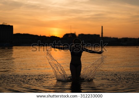 Beautiful  woman swim in the water at sunset