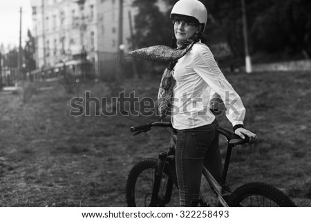 Black and White. Portrait of happy young bicyclist riding in park on her bike