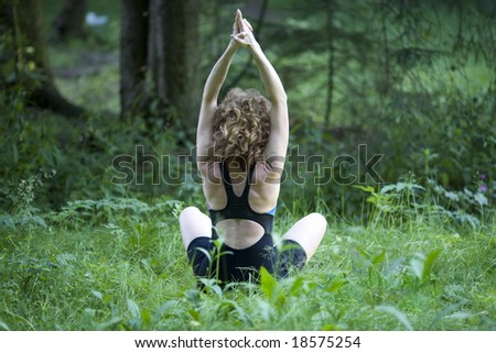 Girl practicing yoga in forest