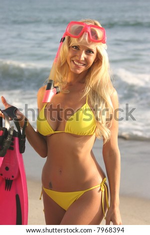 Blond woman with a snorkel,mask and fins on the beach. at Sunset