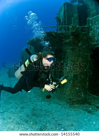 Female Underwater Photographer swimming off the side of a sunken Destroyer