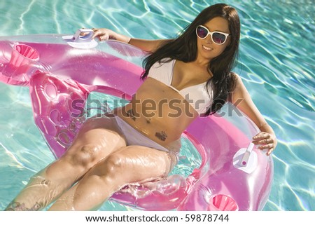 Smiling Brunette Woman sitting in a Pool Chair