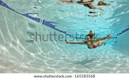 Woman in a Red Bikini Swimming Underwater in a pool