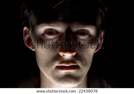 Portrait of the frightened caucasian man on the black background