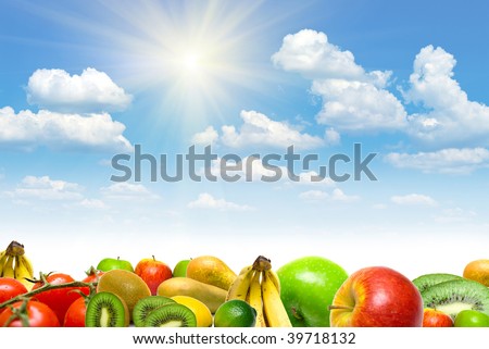 Collage from fruits and vegetables against blue summer cloudy sky