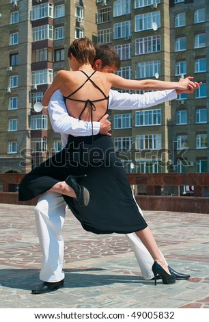 young couple dancing Latino dance against urban landscape