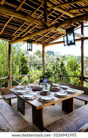 Table set in an outside hut with beatiful views to the forest Foto stock © 