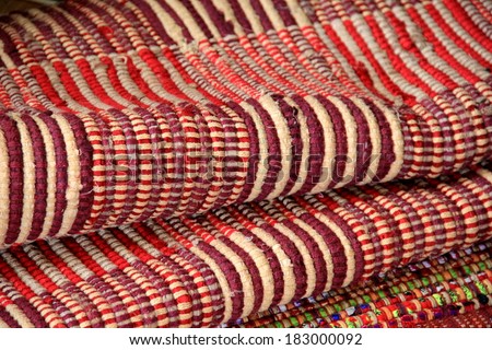 Colorful patterns and textures of woven area rugs layered on top of each other in country shop.