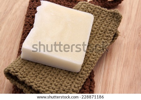 Green and white handmade soap on a wooden background with handmade crochet cotton washcloths