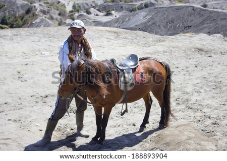 JAVA,INDONESIA-APR 9:Indonesia man with the horse for tourist rent at Mount Bromo on April 9, 2014 in Java, Indonesia.Mt. Bromo is an active volcano and part of the Tengger massif, in East Java.
