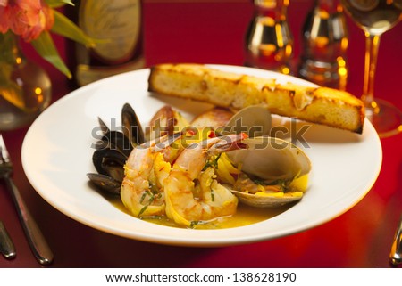 Fancy restaurant seafood appetizer on a white plate with red linen.