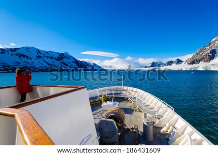 HORNSUND, SVALBARD, NORWAY - JULY 26,  2010:  Photographer on the National Geographic Explorer cruise ship in the Arctic.