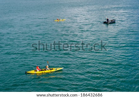 HORNSUND, SVALBARD, NORWAY - JULY 26,  2010: Tourists from the National Geographic Explorer cruise ship on inflatable kayaks in the Artic Ocean exploring a fijord in the Arctic.