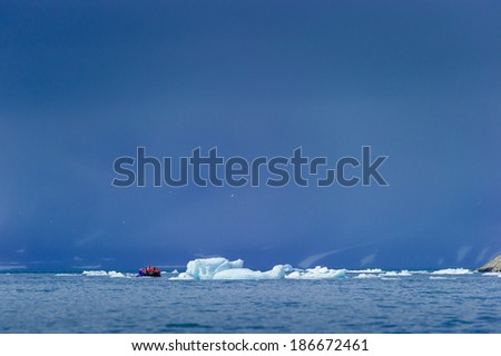 Tourists in inflatable ocean rafts in the Arctic Ocean, Hornsund, Norway.