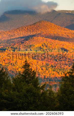 Fall foliage landscape with Trapp Family Lodge and Mt. Mansfield in the background, Stowe, Vermont, USA
