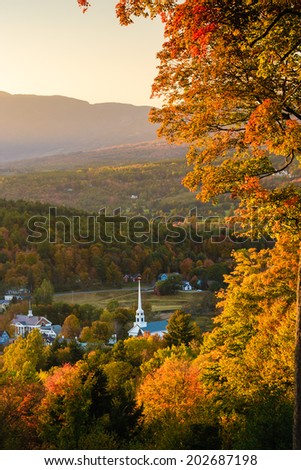 Overlooking a peaceful New England community church and village in an autumn sunset, Stowe, Vermont, USA