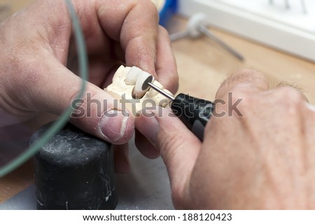 Dental technician in the grinding of artificial teeth