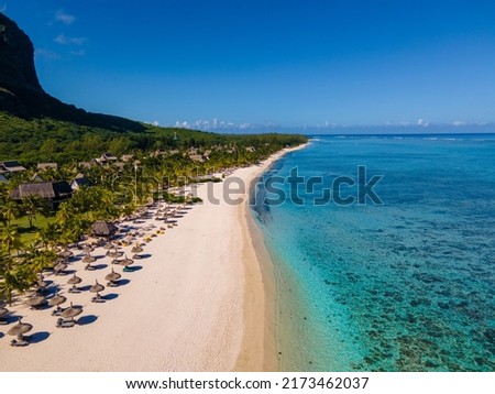 Le Morne beach Mauritius,Tropical beach with palm trees and white sand blue ocean and beach beds with umbrella,Sun chairs and parasol under a palm tree at a tropical beac, Le Morne beach Mauritius Photo stock © 