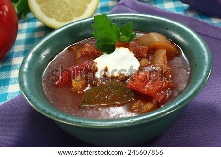 Solyanka in a soup bowl with a dollop of cream