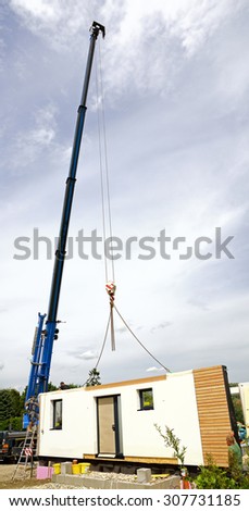 wall of a prefabricated house hanging on a crane