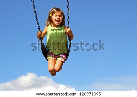 Little girl swinging high above clouds