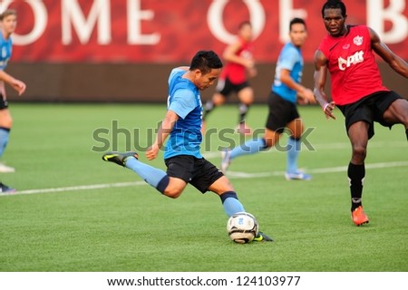 PATHUMTHANI,THAILAND-9 JANUARY 2013 : Ekaphan Players of Bangkok Glass FC(blue) in action during a friendly match between Bangkok Glass FC and PttrayongFC  at Leo Stadium on JAN 9,2013 in Thailand