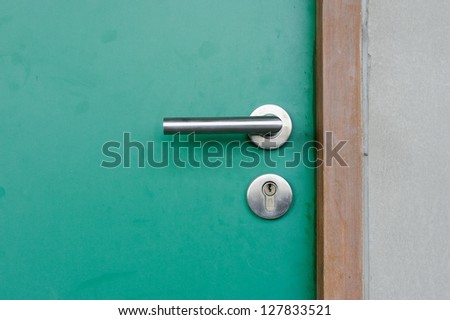 Aluminium door knob on the green door