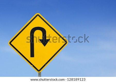 U-Turn road sign on a blue sky background with copy space