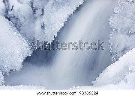 Winter waterfall captured with motion blur and framed by ice, Orangeville Creek, Michigan, USA