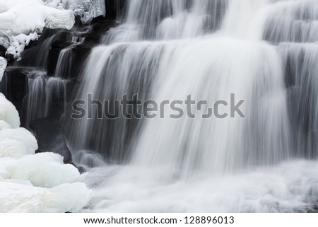 Winter, Bond Falls cascade framed by ice and snow and captured with motion blur, Michigan\'s Upper Peninsula, USA