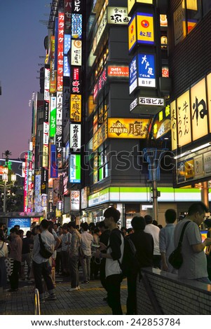 SHINJUKU, TOKYO - MAY 31, 2014: Street view of Shinjuku commercial district at night. Many neon sign billboards along the commercial buildings. Shinjuku is one of the biggest & busiest town in Japan.