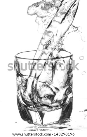water pouring and splashing in glass isolated on white background