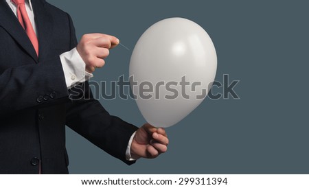 Businessman in Suit lets a Balloon burst with a needle