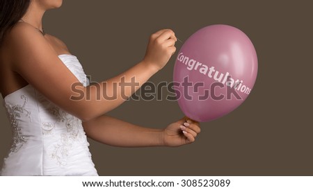 Young bride in wedding dress lets a Balloon with Text burst with a needle