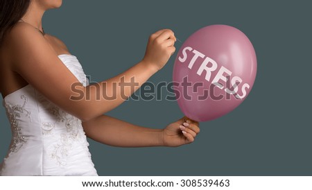 Young bride in wedding dress lets a Balloon burst with a needle