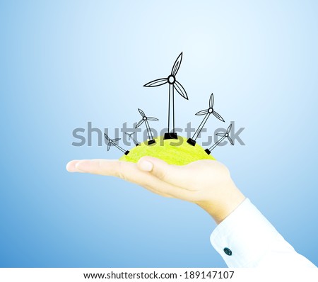 wind generator on green world by hand