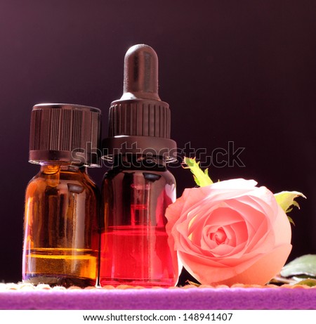 Two bottles essential oil and rose flower on bamboo mat, come on, let\'s go spa.