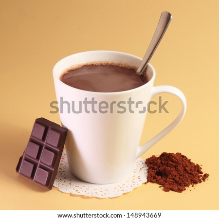 Hot chocolate drink , chocolate and powder on simple yellow background
