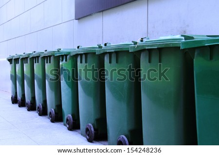 Row of green and clean rubbish bins on the street.